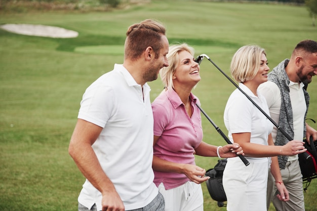 Groep stijlvolle vrienden op de golfbaan leren een nieuw spel te spelen. Het team gaat rusten na de wedstrijd