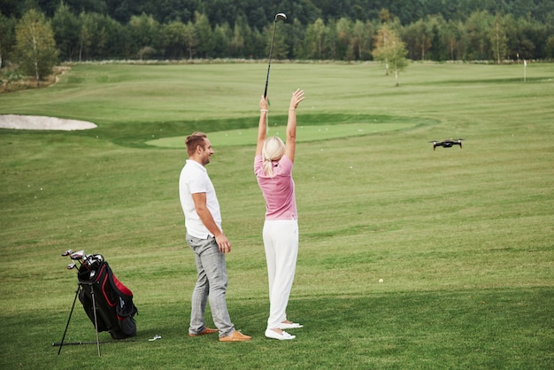 Groep stijlvolle vrienden op de golfbaan leren een nieuw spel te spelen