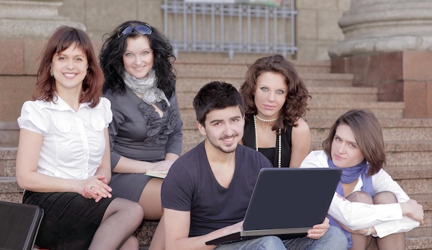 Groep studenten communiceren via internet met behulp van laptop