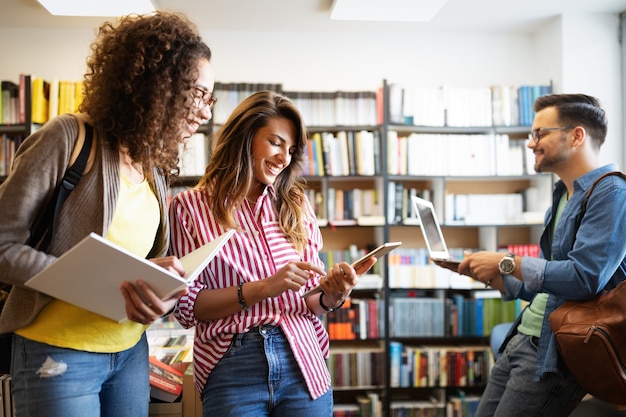 Groep studenten die in de schoolbibliotheek studeren. studie, vrienden, onderwijsconcept.