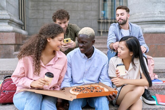 Groep studenten kijken naar een hete pizza in een doos