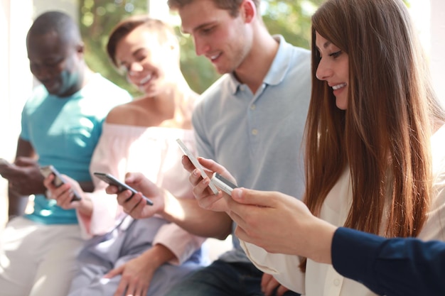 Groep studenten kijken naar smartphones. Jongeren verslaving aan nieuwe technologische trends.