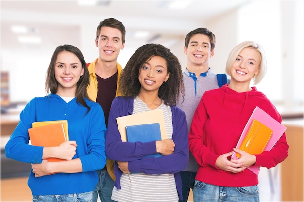 Groep studenten met boeken die naar de camera glimlachen