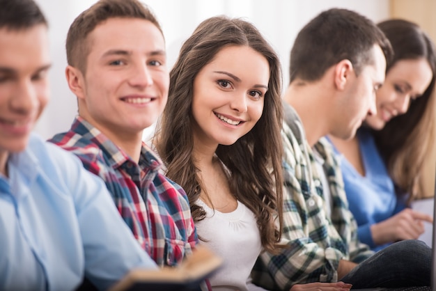 Groep studenten zitten op de vloer.