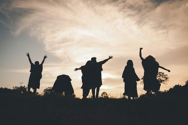 Groep teamwerkmensen springen vrijheid gelukkig spelen bij zomerzonsondergang in de natuur