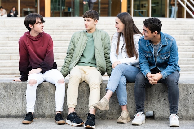 Groep tieners praten zittend op een bankje