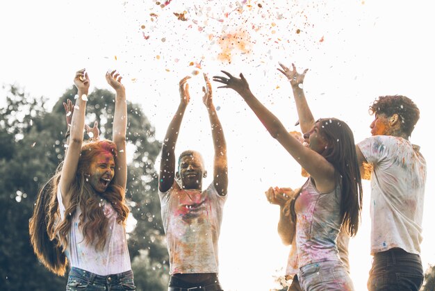 Groep tieners spelen met kleuren op het holi festival, in een park