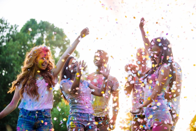 Groep tieners spelen met kleuren op het holi festival, in een park