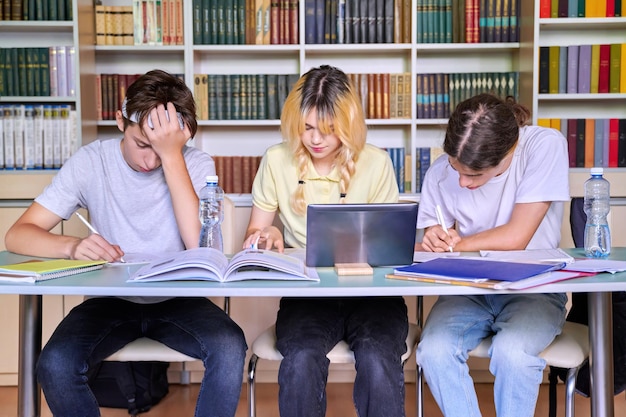 Groep tienerstudenten die in de schoolbibliotheek studeren