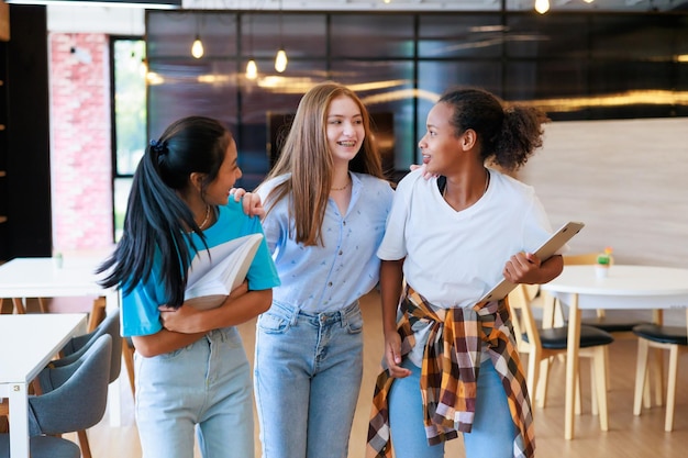 Groep tienerstudenten die lopen om te leunen in de bibliotheek van de school universiteitsbibliotheekonderwijs en studentenleerconcept