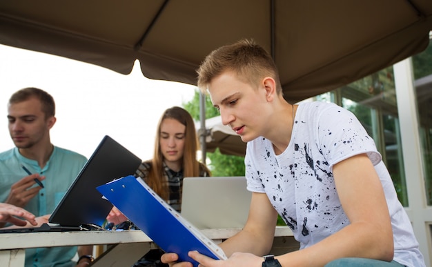 Groep tienerstudenten in Park met laptop en boeken