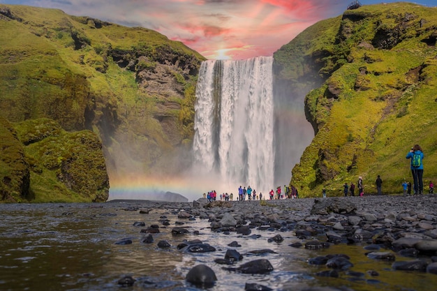 Groep toeristen die naar de prachtige regenboog kijken bij de indrukwekkende Skogarfoss