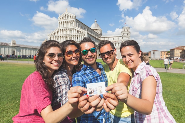 Groep toeristen met hun foto in Pisa.