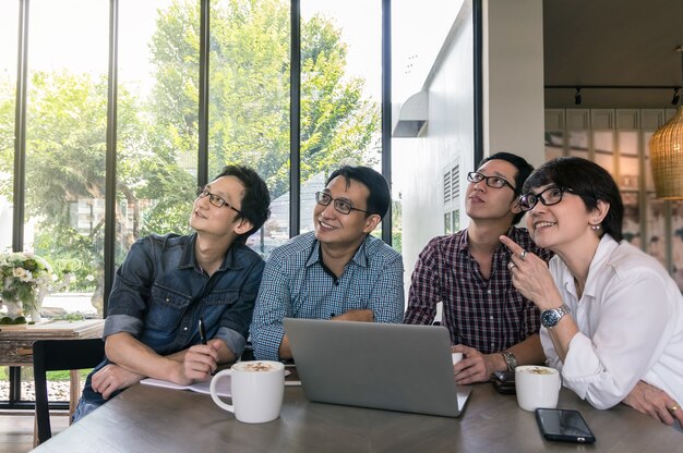 Groep van Aziatische zakenmensen met casual pak ontmoeten en op zoek naar de richting