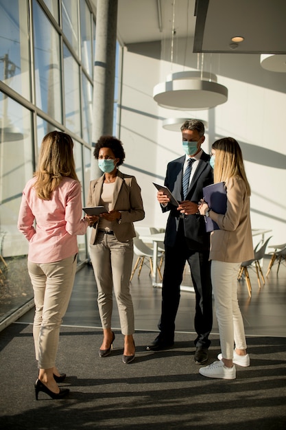 Groep van Aziatische zakenmensen ontmoeten en werken in kantoor en dragen masker voor het voorkomen van infectie door coronavirus