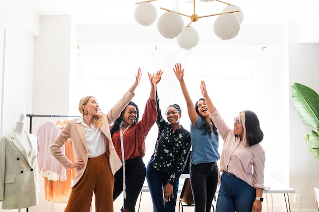 Groep van diverse vrouwen vieren succes Vrouwen highfiving glimlachen en vieren Diverse vrouwen in mode zakelijk succes vieren en glimlachen samen voor zakelijk succes vrouwen macht