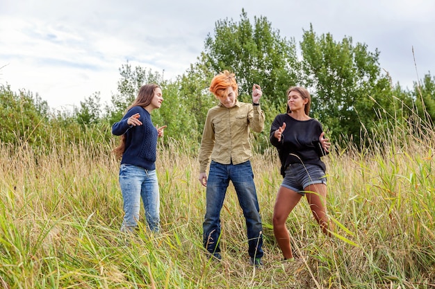 Groep van drie vriendenjongen en twee meisjes die en samen buiten plezier dansen