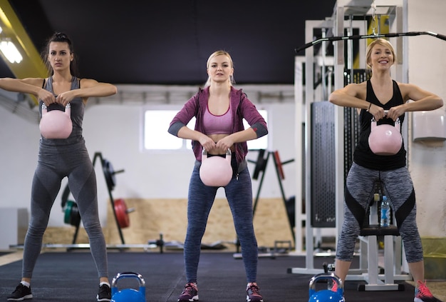 groep van gezonde jonge atleten doen oefeningen met kettlebells op cross fitness-studio