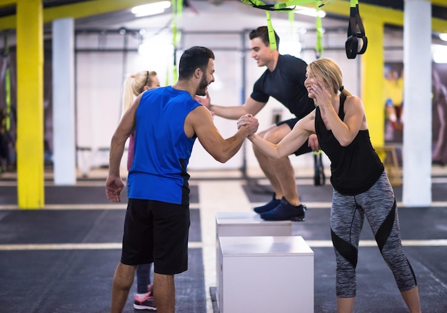 groep van jonge gezonde atletische mensen opleiding springen op fit box op cross fitness gym