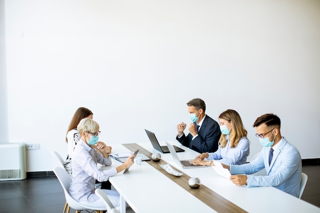 Groep van mensen uit het bedrijfsleven met jonge volwassenen en senior vrouw collega over bijeenkomst in het moderne, lichte kantoor interieur