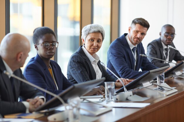 Groep van mensen uit het bedrijfsleven nieuw project samen in team bespreken tijdens bijeenkomst in de directiekamer