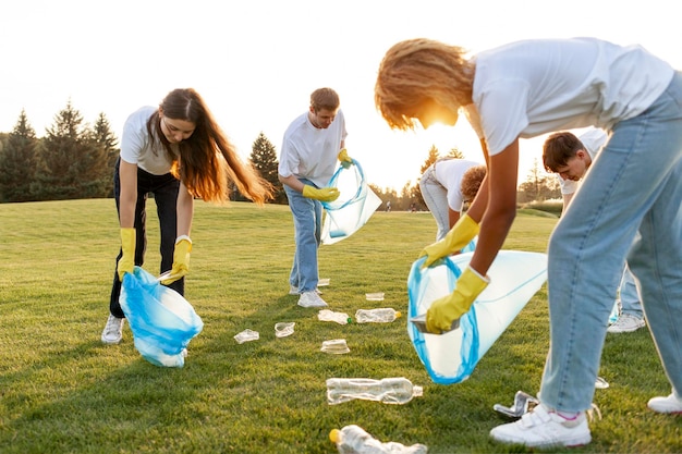 Foto groep van multiraciale mensen in handschoenen en met vuilniszakken verwijderen plastic en vuilnis in het park