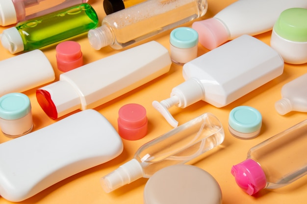 Groep van plastic lichaamsverzorging fles plat lag samenstelling met cosmetische producten op gekleurde oppervlakte lege ruimte voor u ontwerpen