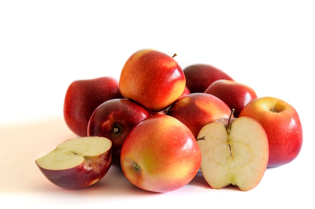 Groep van rode verse appels, geheel en gesneden, op de witte achtergrond.