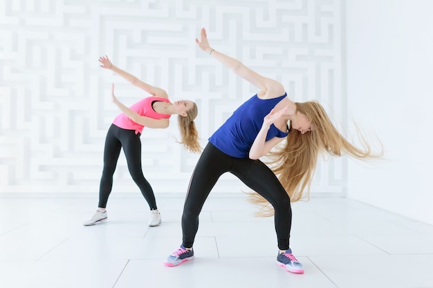 Groep van twee jonge vrouwen die een fitness-danstraining doen