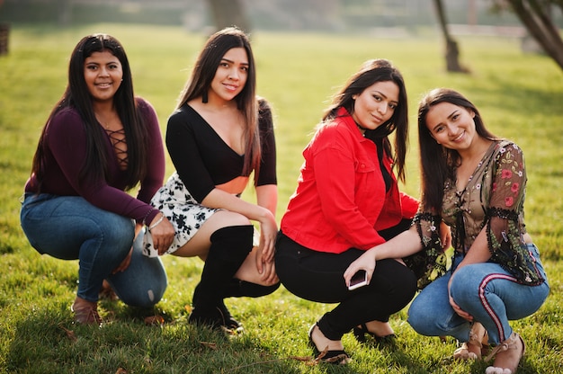 Groep van vier gelukkige en mooie latino meisjes uit Ecuador die op straat worden gesteld.