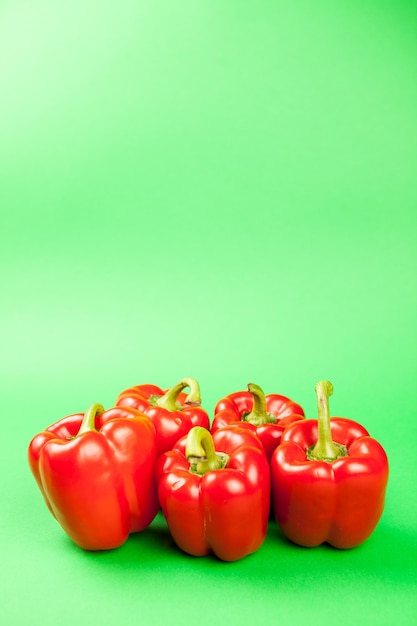 Groep van vijf verse en gezonde zoete rode pepperson groene achtergrond