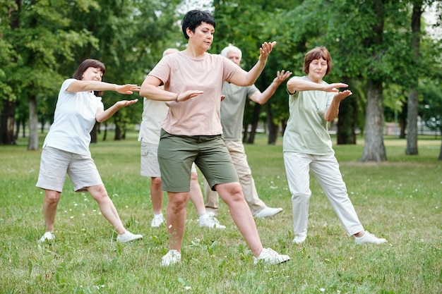 Groep volwassen mensen die trainen tijdens sporttraining in het park buiten