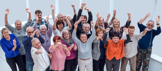 Groep volwassen vrienden staken hun handen op en vierden succes