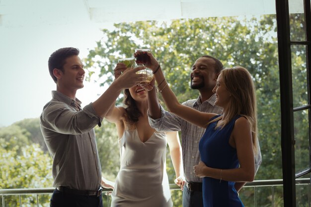 Groep vrienden die cocktailglazen roosteren