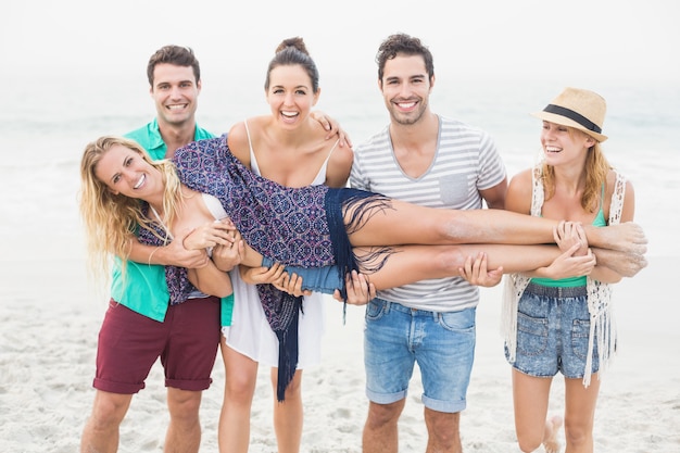 Groep vrienden die een vrouw opheffen