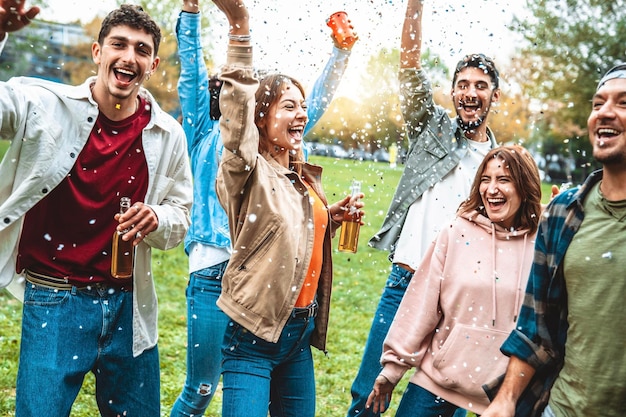 Groep vrienden die genieten van feest en confetti in de lucht gooien