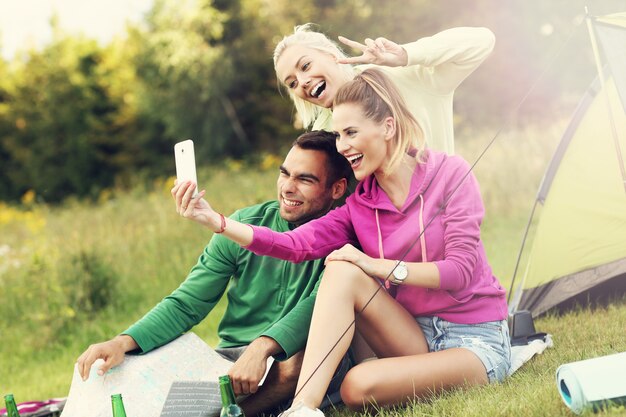 Groep vrienden die in het bos kamperen en selfie maken