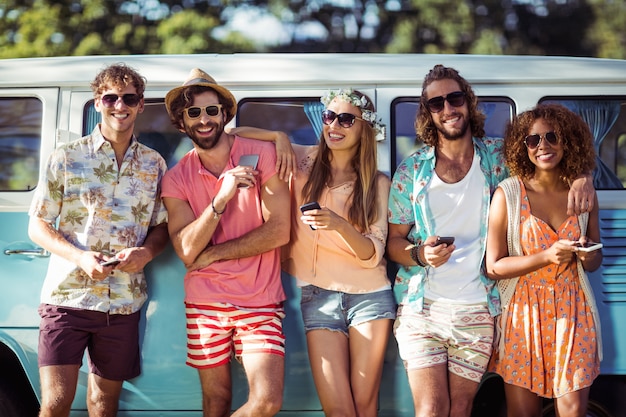 Groep vrienden die mobiele telefoon en het glimlachen houden