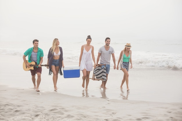 Groep vrienden die op het strand lopen