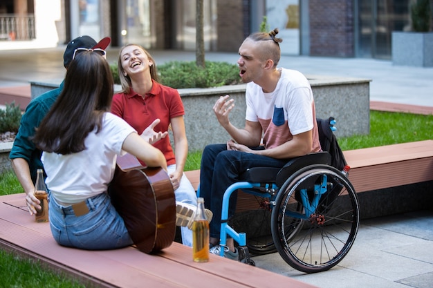 Groep vrienden die op zomerdag een wandeling maken door de straat van de stad