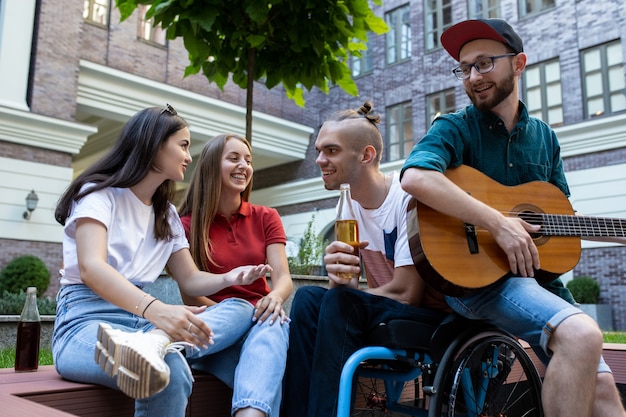 Groep vrienden die op zomerdag een wandeling maken door de straat van de stad