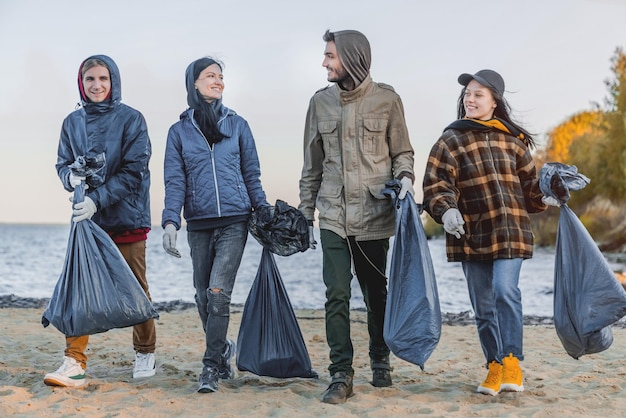 Groep vrienden die plastic verzamelen op het strand