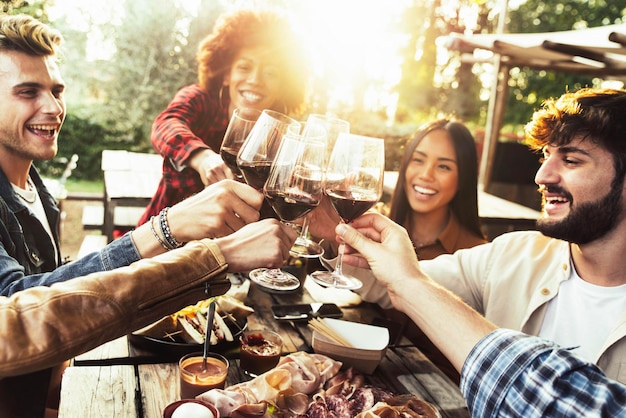 Groep vrienden die plezier hebben tijdens het bbq-diner in het tuinrestaurant