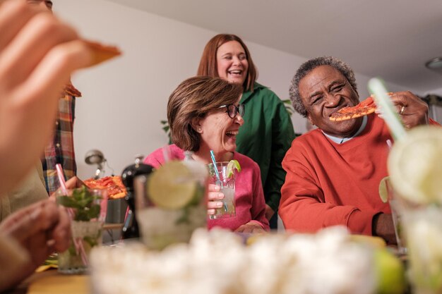 Groep vrienden die samen eten en goede tijden delen bij een leuke maaltijd Concept levensstijl