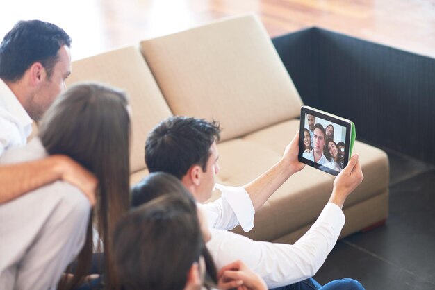 groep vrienden die selfie-foto's maken met tablet in een modern huis binnenshuis