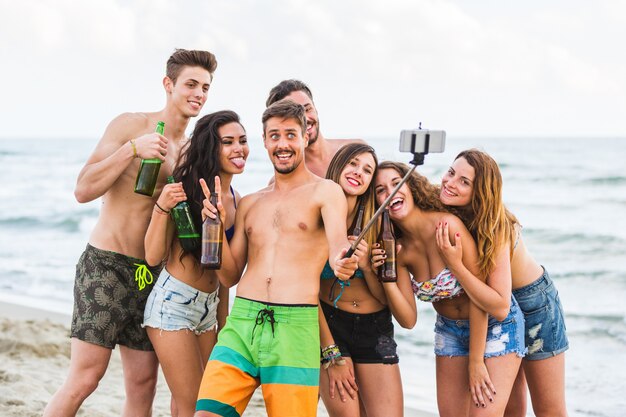 Groep vrienden die selfie op het strand nemen