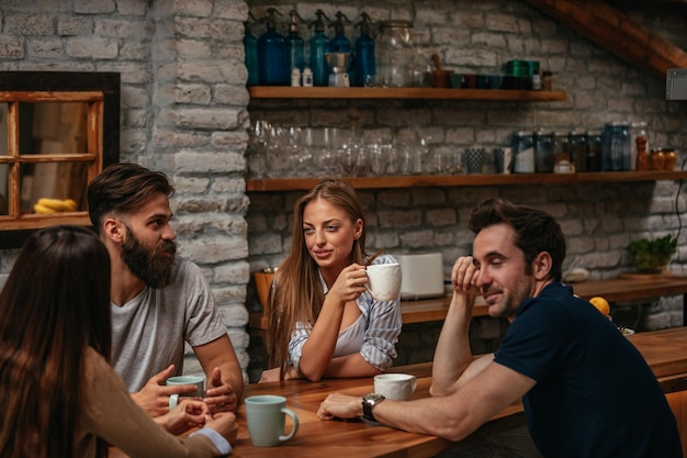 Groep vrienden die thuis bij de koffie kletsen