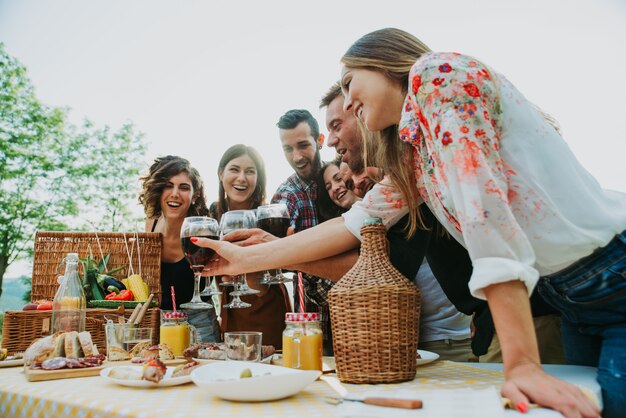 Groep vrienden die tijd doorbrengen die een picknick en een barbecue maken