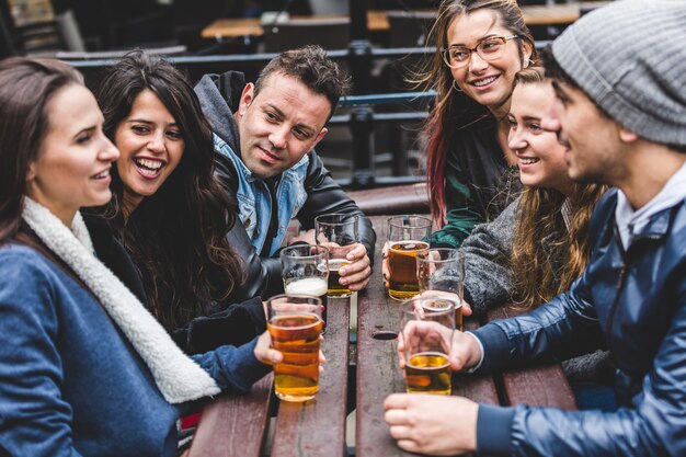 Groep vrienden die van een bier genieten bij bar in londen