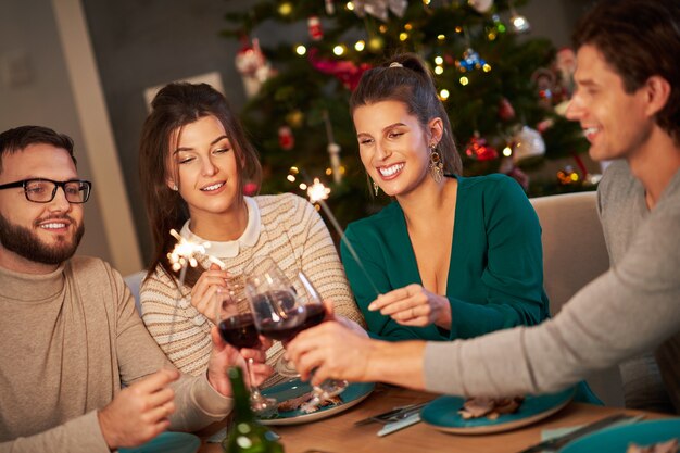 groep vrienden die wijn drinken en thuis Kerstmis vieren